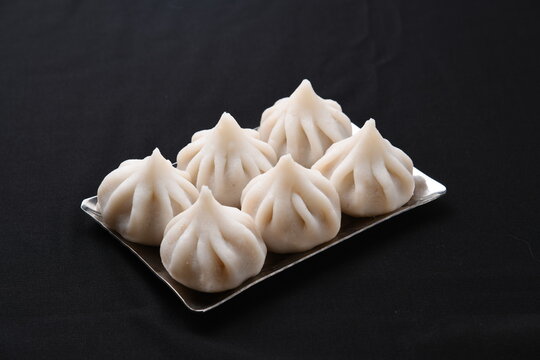 ukadiche modak in flater dish on black background