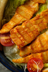 Sizzling grilled chicken fillets rest atop crisp lettuce, accompanied by juicy cherry tomatoes. The vibrant colors and enticing aroma invite a delightful dining experience