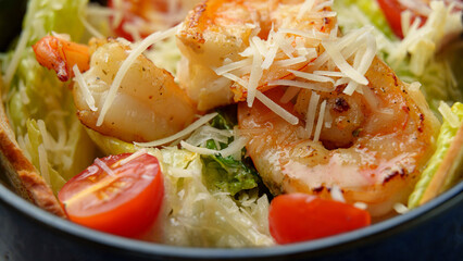 Bright and colorful salad features perfectly grilled shrimp atop crisp lettuce and juicy cherry tomatoes. A sprinkle of cheese adds a tasty finish, perfect for warm days