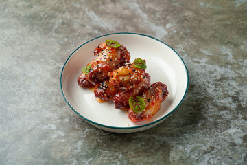 Succulent chicken wings glazed to perfection with sticky sauce, enhanced by a sprinkle of sesame seeds and vibrant herbs, creating a mouthwatering feast for any gathering