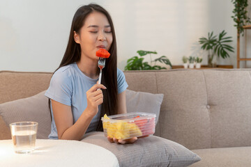 Woman enjoying fresh fruit at home