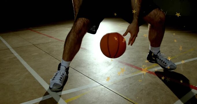 Male basketball player starting through-legs dribbling ball on court training star over right leg