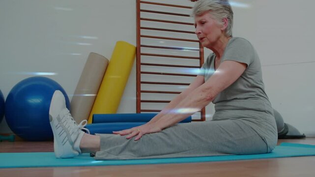 Senior woman starting on blue mat, reaching toes, holding rehab leg or back stretch, returning smili