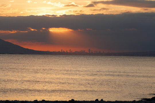 Rayos de sol sobre Benidorm al atardecer en el horizonte desde Calpe, Espa&ntilde;a