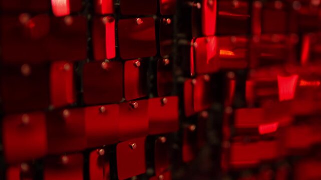 Iridescent red sequins hang on the wall as a beautiful backdrop