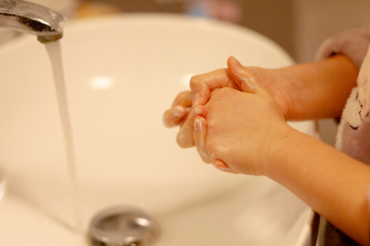 Close up delle mani di una ragazza mentre se le lava con acqua e sapone