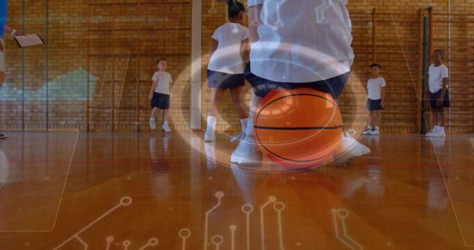 Kid kneeling holding basketball in gym, coach timing, overlay rotating around ball guiding PE drill