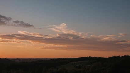 Obraz premium Sunset sky with clouds over a landscape, natural scenery.