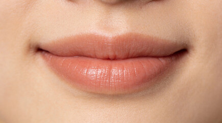 Extreme close-up of a delicate smile with soft lip curves and subtle natural texture. Minimal composition with clean studio lighting, detailed and realistic macro aesthetic