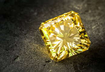 A yellow diamond is sitting on a grey surface