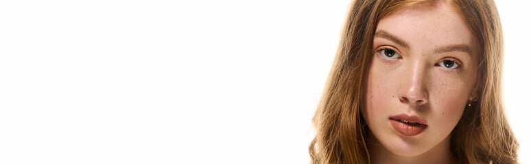 Obraz premium Redhead woman in white studio showcasing natural beauty and skincare