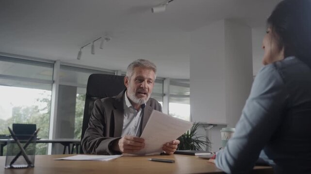 Mature woman discussing her financial future with a cinfident male financial planner.