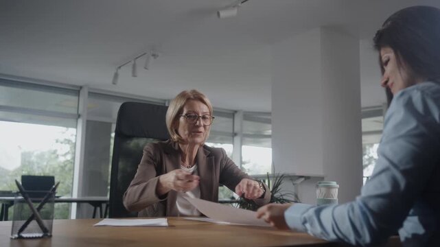 Mature woman discussing her financial future with a cinfident female financial planner.