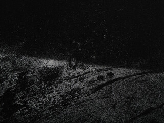 Grunge chalk texture background. A thin layer of snow dust settles over a rough dark surface. The texture feels cold, soft, and atmospheric. Can be used as elements for design projects. 