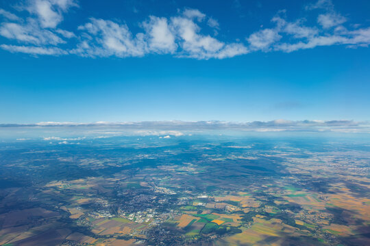 Aerial view of countryside under bright blue sky with clouds