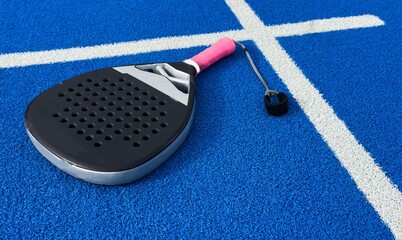 Paddle tennis: Paddel racket in front of an outdoor court
