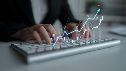 Business professional typing on keyboard with digital graphs illustrating positive trends and data...