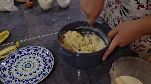 A close-up shot captures a woman's hands skillfully mixing ingredients for a delicious treat in a warm home kitchen. Perfect for recipes, cooking tutorials, or healthy lifestyle content.