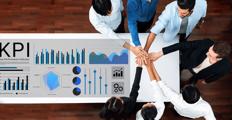 Diverse team collaborating around a KPI dashboard, showcasing graphs and charts that indicate performance metrics, fostering discussion, strategy, and growth. Gantry