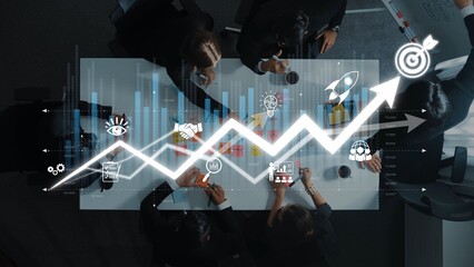Aerial view of a business meeting featuring data visualization and growth projections, showcasing teamwork, innovative strategies, and collaborative planning in a modern office setting. Raster