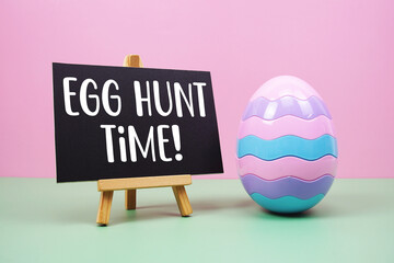Egg Hunt Time! text with egg on pink and green background