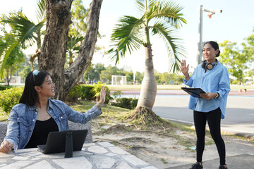 An Asian freelance woman arranges an off-site work meeting with a friend.