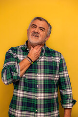 Fototapeta premium vertical Elderly man feeling sore throat pain and discomfort