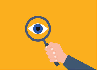 Business research. Hand holding a magnifying glass with eye.
