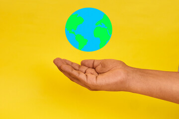 A hand holding a floating globe to symbolize global connection, responsibility and the shared concept of caring for the world.
