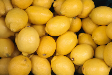 Fresh organic yellow lemons filling the frame, creating a vibrant background for healthy food and citrus products