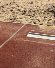 Long jump pit and runway at an outdoor athletics field on a sunny day