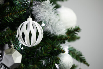 White Christmas ornament hanging on a festive tree