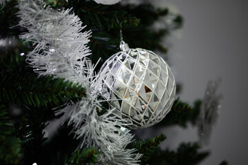 Silver disco ball ornament hanging on Christmas tree