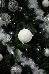 Christmas tree decorated with white and silver ornaments