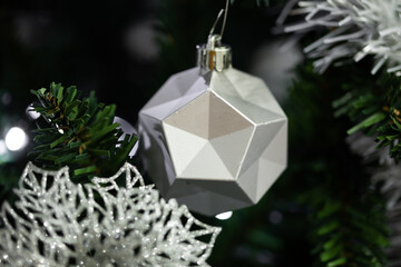 White geometric Christmas ornament hanging on tree