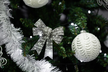 Christmas tree decorating with silver ornaments and festive bow