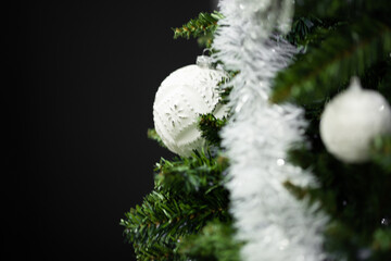 Christmas tree decorating with white ornaments and garland