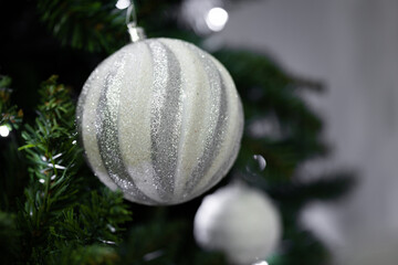 Glittering silver Christmas ornament decorating a festive tree