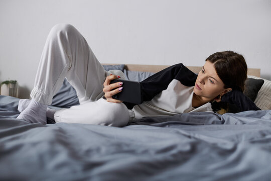 Young woman embraces a day of relaxation while bed rotting in her cozy apartment space