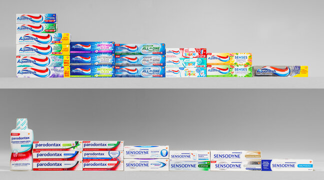A shelf full of toothpaste tubes, including Sensodyne, Colgate, and Crest