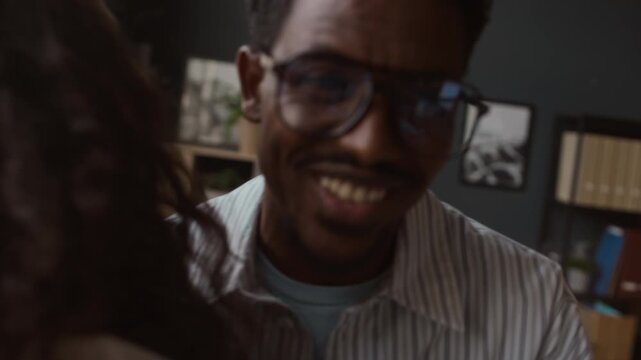 Close up of biracial colleagues hugging each other after successful conference in modern office