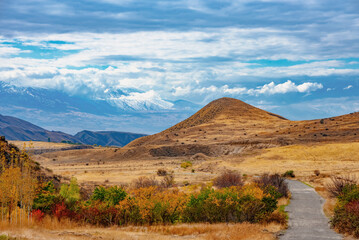 A mountain range is visible in the background, with a road leading up to a hill