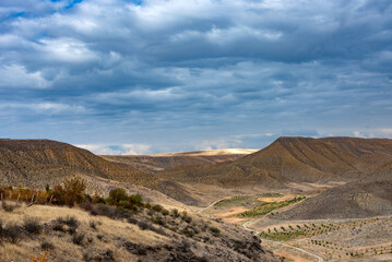 A desolate desert landscape with a cloudy sky