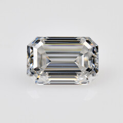 A white emerald cut diamond is sitting on a white background