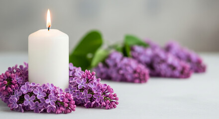 Soft focus memorial scene featuring lit white candle surrounded by purple lilac flowers on neutral background for remembrance and sympathy design use