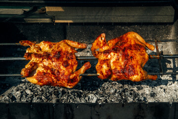 Two pieces of chicken are being cooked on a grill