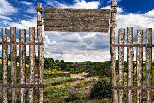 Fence and gate made of logs on the background of a natural landscape