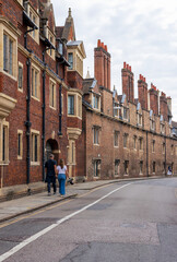 Fototapeta premium An empty alley in Cambridge old town with traditional terraced houses and Cambridge cathedral. 