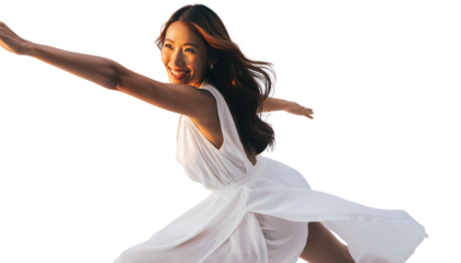 Carefree woman in white dress running happily outdoors during golden hour