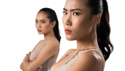 Young women expressing conflict and strong emotions in studio portrait; one stares sternly, other looks away with crossed arms